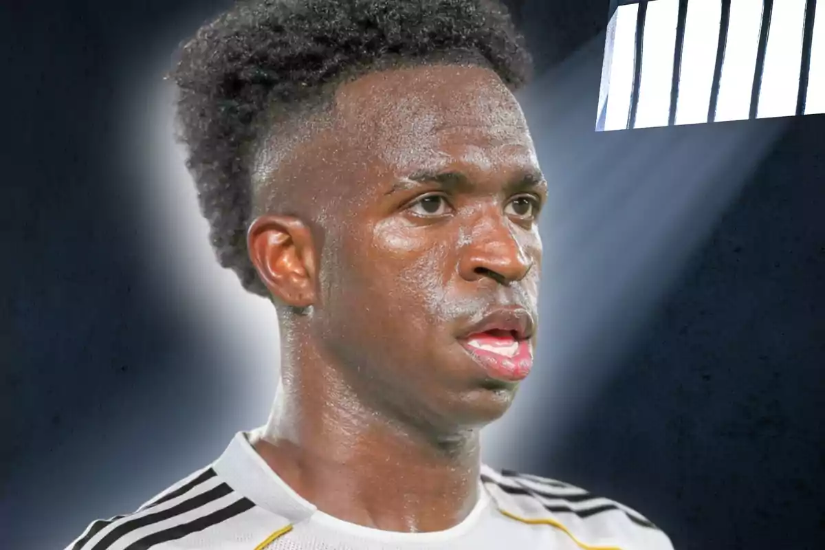 Futbolista amb samarreta blanca i negra sota una llum intensa amb fons fosc