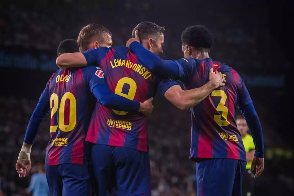 Tres jugadors del FC Barcelona s’abracen celebrant un gol durant un partit de futbol