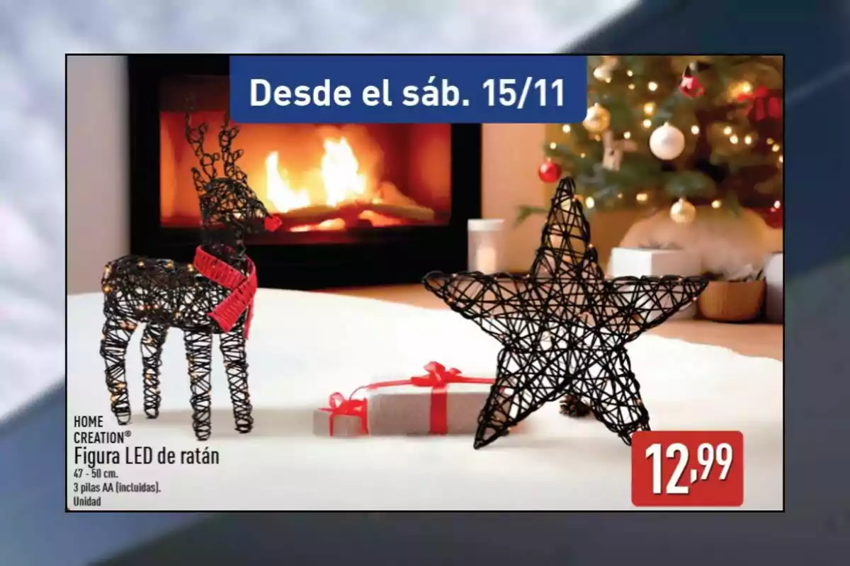 Decoració nadalenca amb figures de vímet en forma de cérvol i estrella il·luminades amb llums LED, al costat d’un regal embolicat, davant d’una llar de foc encesa i un arbre de Nadal decorat, amb un preu de 12,99 euros.