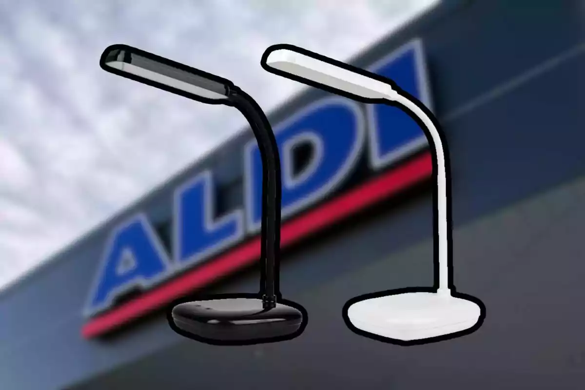 Dues làmpades d’escriptori, una negra i una blanca, davant de la façana desenfocada d’una botiga Aldi.