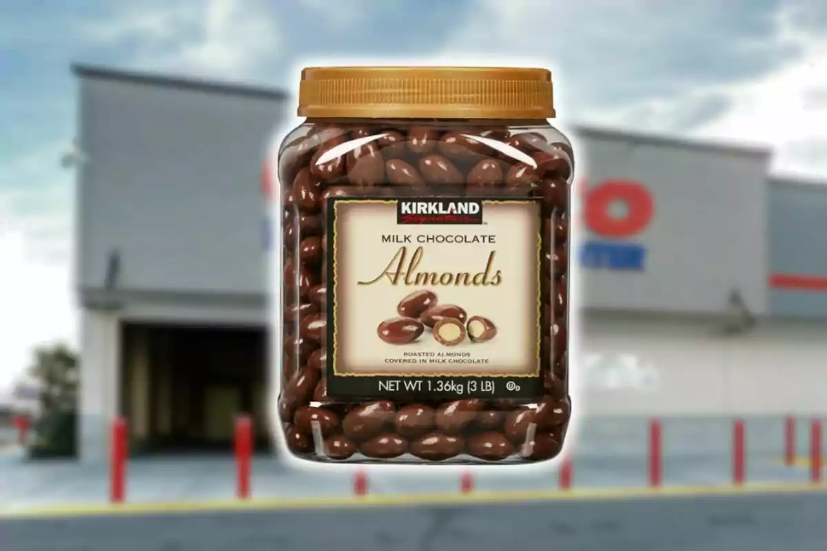 Large jar of Kirkland brand milk chocolate covered almonds in front of a blurred store. Large jar of Kirkland brand milk chocolate covered almonds in front of a blurred store.