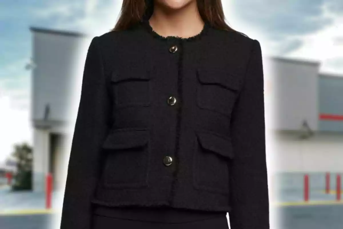 Mujer vistiendo una americana negra de manga larga con cuatro bolsillos y botones metálicos al frente de Costco, de pie frente a una de sus tiendas en Estados Unidos.