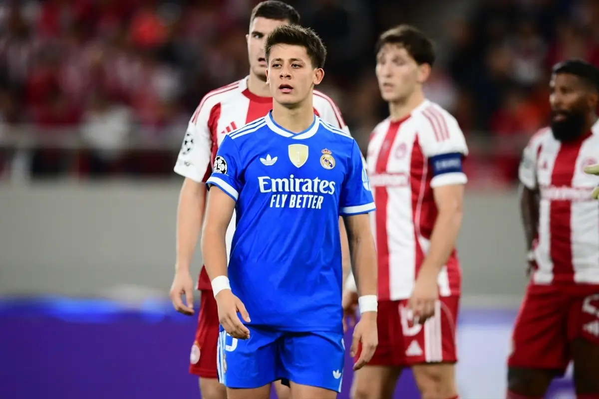 Jugador del Real Madrid con uniforme azul en un partido de fútbol frente a jugadores del equipo rival con uniforme blanco y rojo