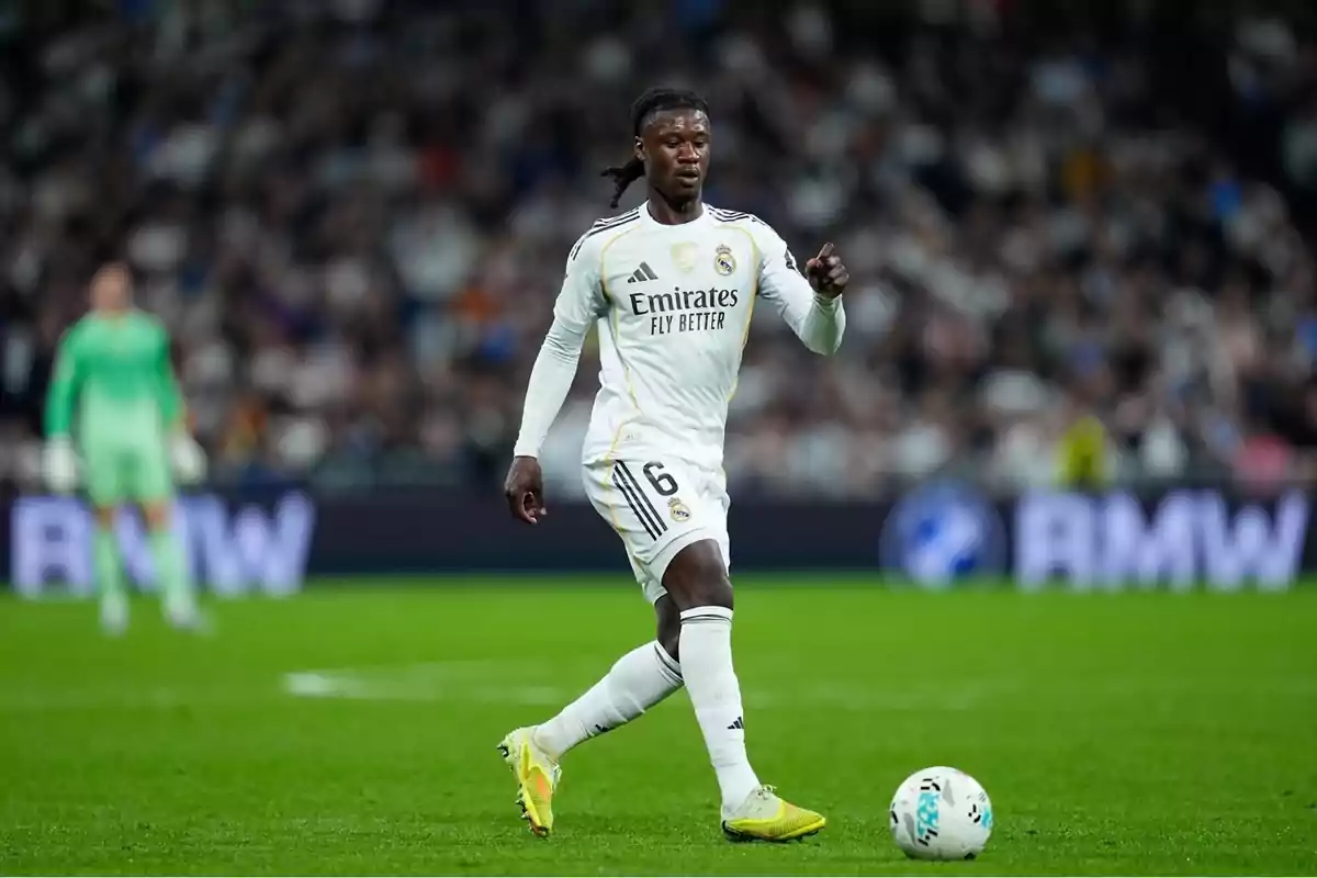 Futbolista del Real Madrid con el uniforme blanco controlando el balón en un partido Futbolista del Real Madrid con el uniforme blanco controlando el balón en un partido