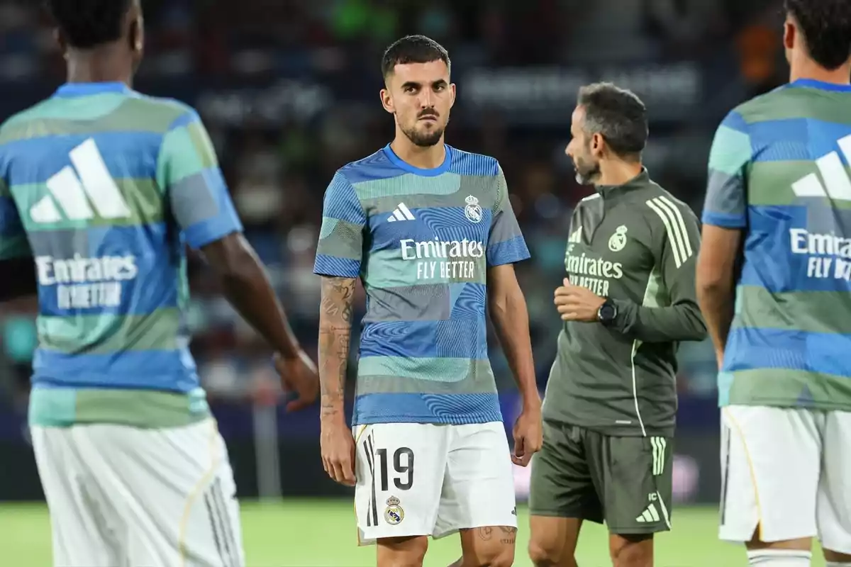 Futbolistes del Reial Madrid amb l’uniforme d’entrenament conversen al camp abans d’un partit