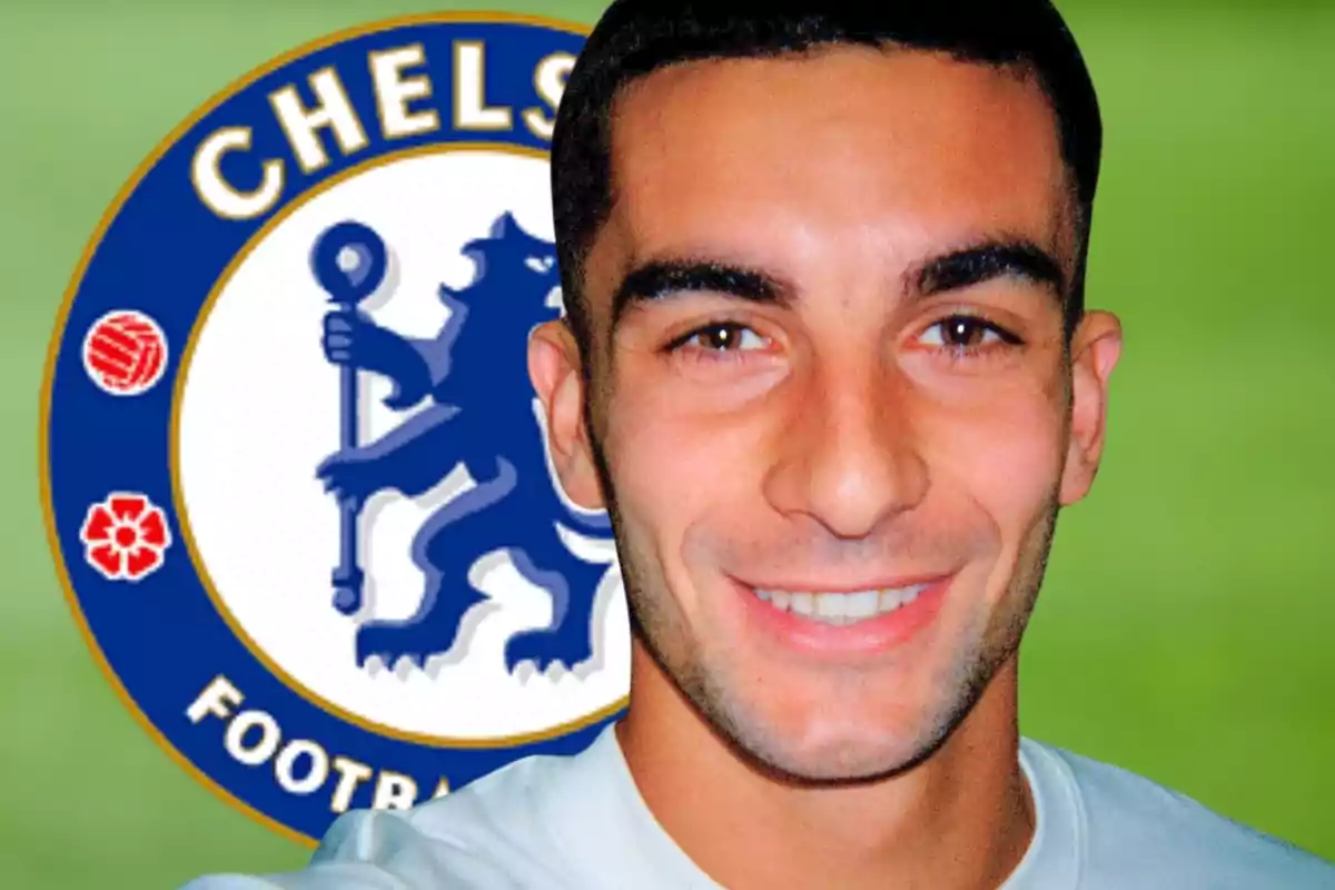 Un hombre sonriente con el logo del Chelsea de fondo