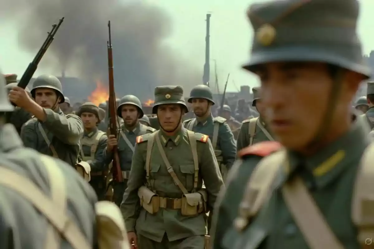 Soldats amb uniformes militars desfilen en formació mentre al fons s’observa fum i foc. Soldats amb uniformes militars desfilen en formació mentre al fons s’observa fum i foc.