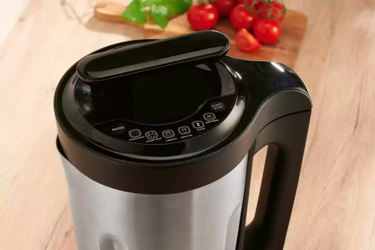 Sopera elèctrica d’acer inoxidable amb controls digitals en una cuina i tomàquets al fons