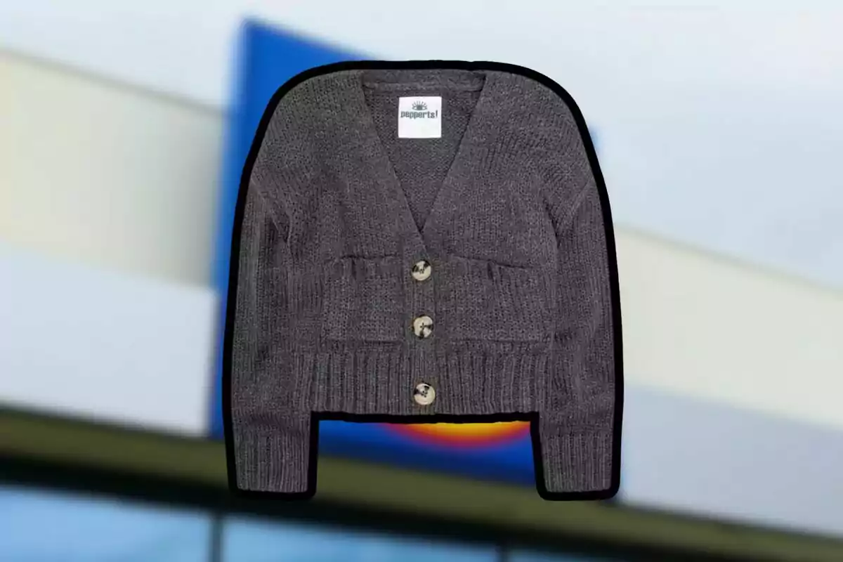 Gray knit sweater with large buttons on the front against a blurred background