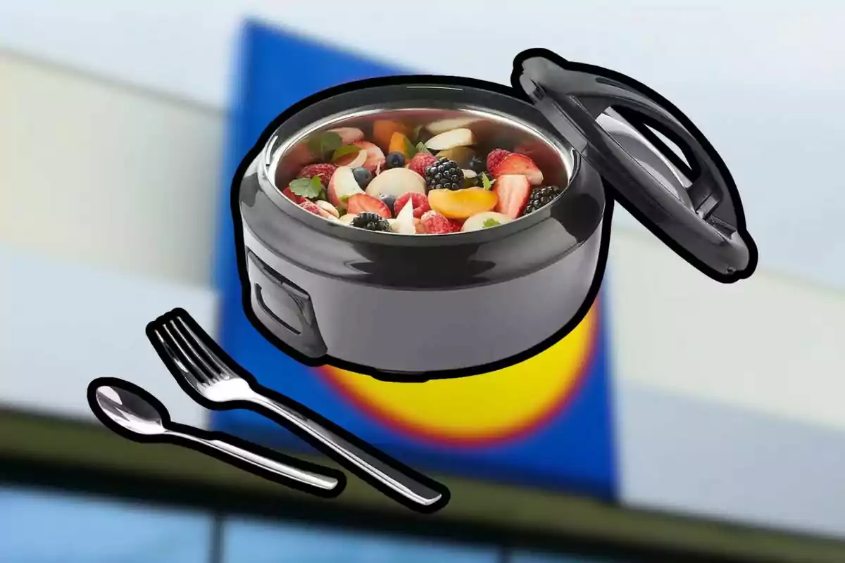 Olla eléctrica con ensalada de frutas y cubiertos sobre un fondo desenfocado de colores azul y amarillo Olla eléctrica con ensalada de frutas y cubiertos sobre un fondo desenfocado de colores azul y amarillo