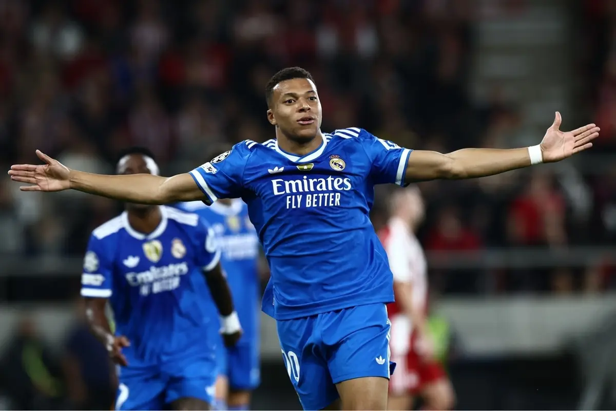 Futbolista del Real Madrid celebrando un gol con los brazos extendidos durante un partido