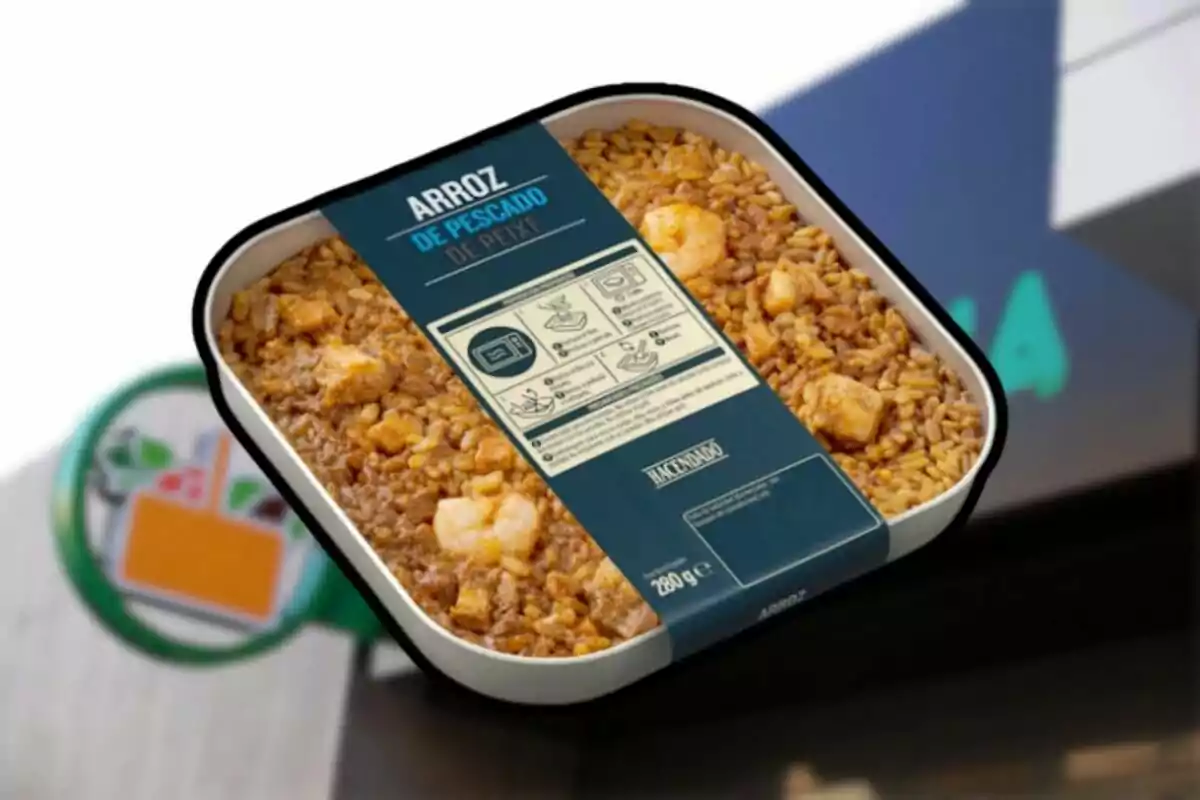 Envàs d’arròs de peix preparat de la marca Hacendado sostingut davant d’un supermercat Envàs d’arròs de peix preparat de la marca Hacendado sostingut davant d’un supermercat