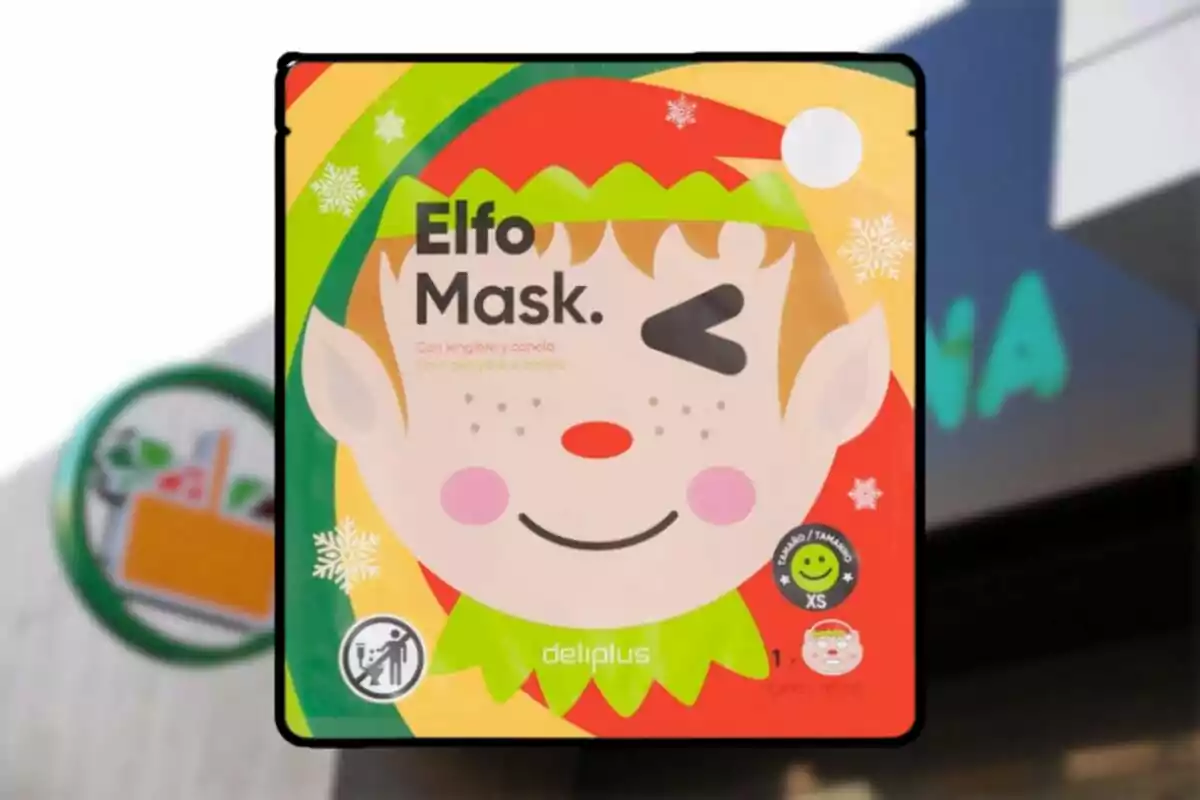 Envàs colorit de màscara facial infantil amb disseny d’elf somrient i fent l’ullet, de la marca Deliplus, amb detalls de flocs de neu i fons nadalenc.