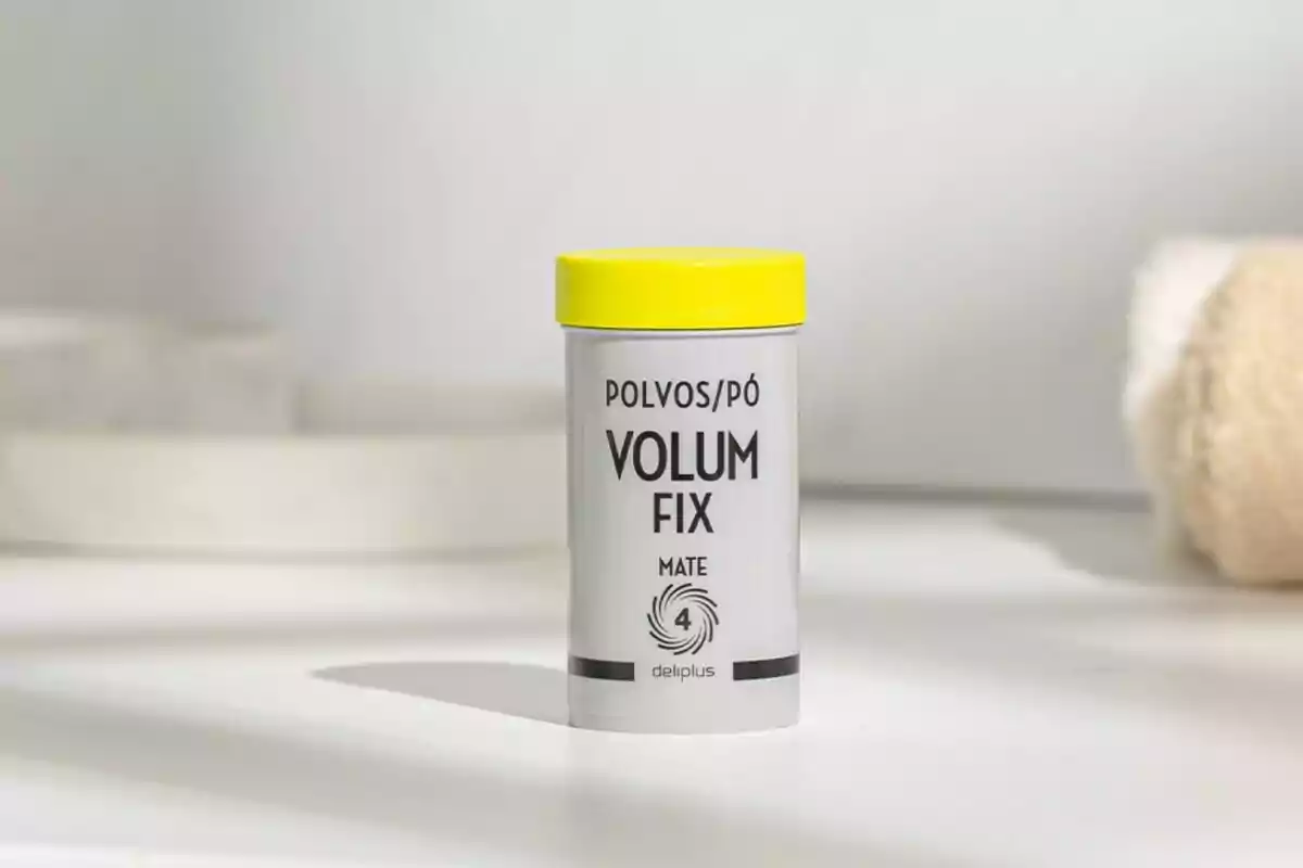 Envàs de pols Volum Fix mat de la marca Deliplus amb tapa groga sobre una superfície blanca