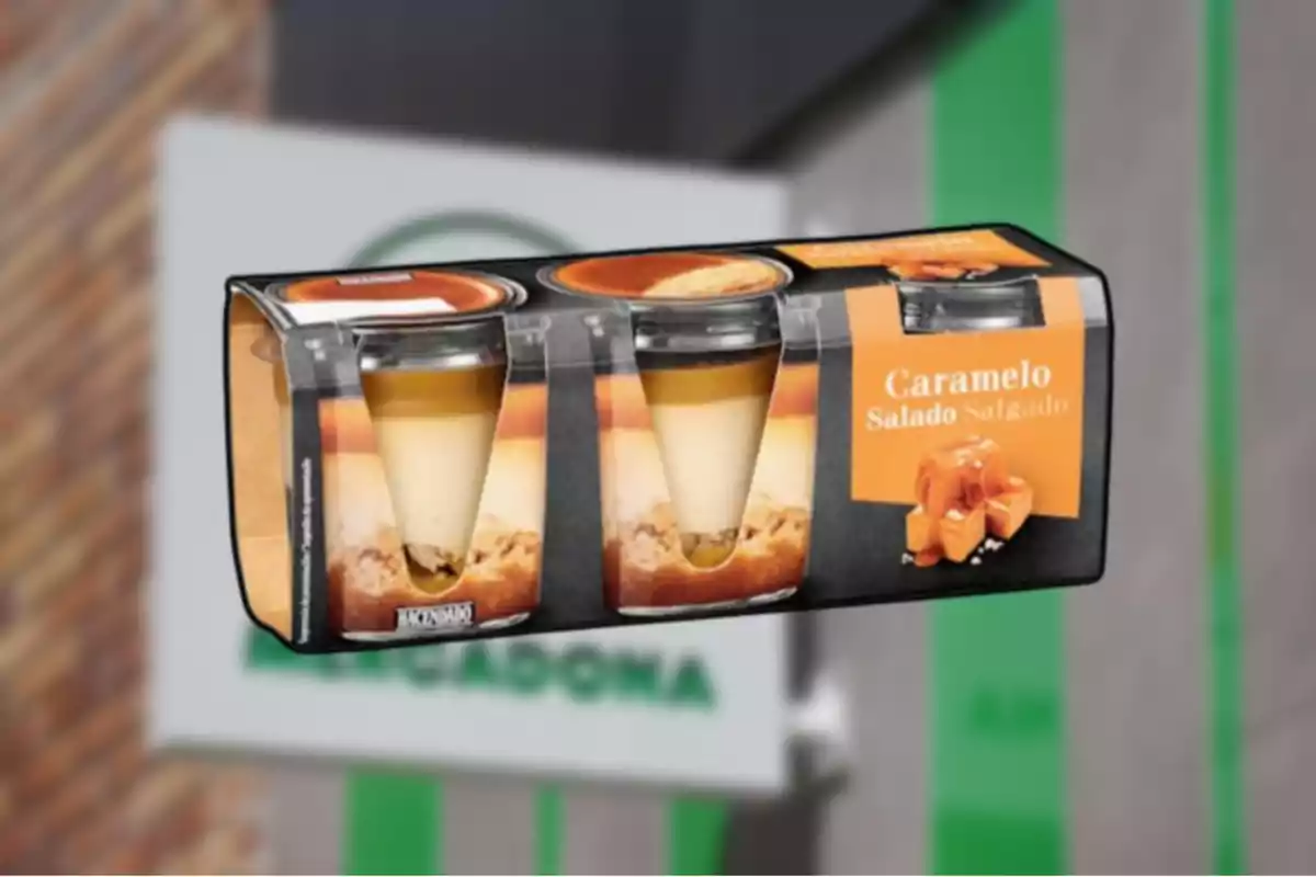Postres de caramel salat de la marca Hacendado en un envàs de quatre unitats davant d’una botiga Mercadona desenfocada