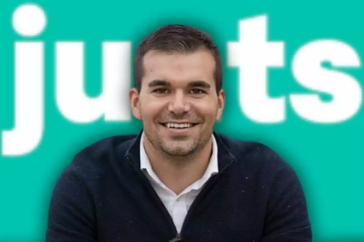 Home jove somrient amb fons turquesa i lletres blanques grans desenfocades Home jove somrient amb fons turquesa i lletres blanques grans desenfocades