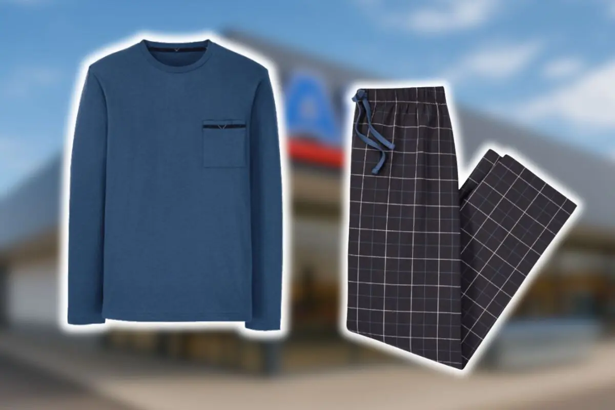 Pijama de hombre de Aldi formado por una camiseta azul de manga larga y pantalón oscuro con cuadros blancos sobre un fondo desenfocado.