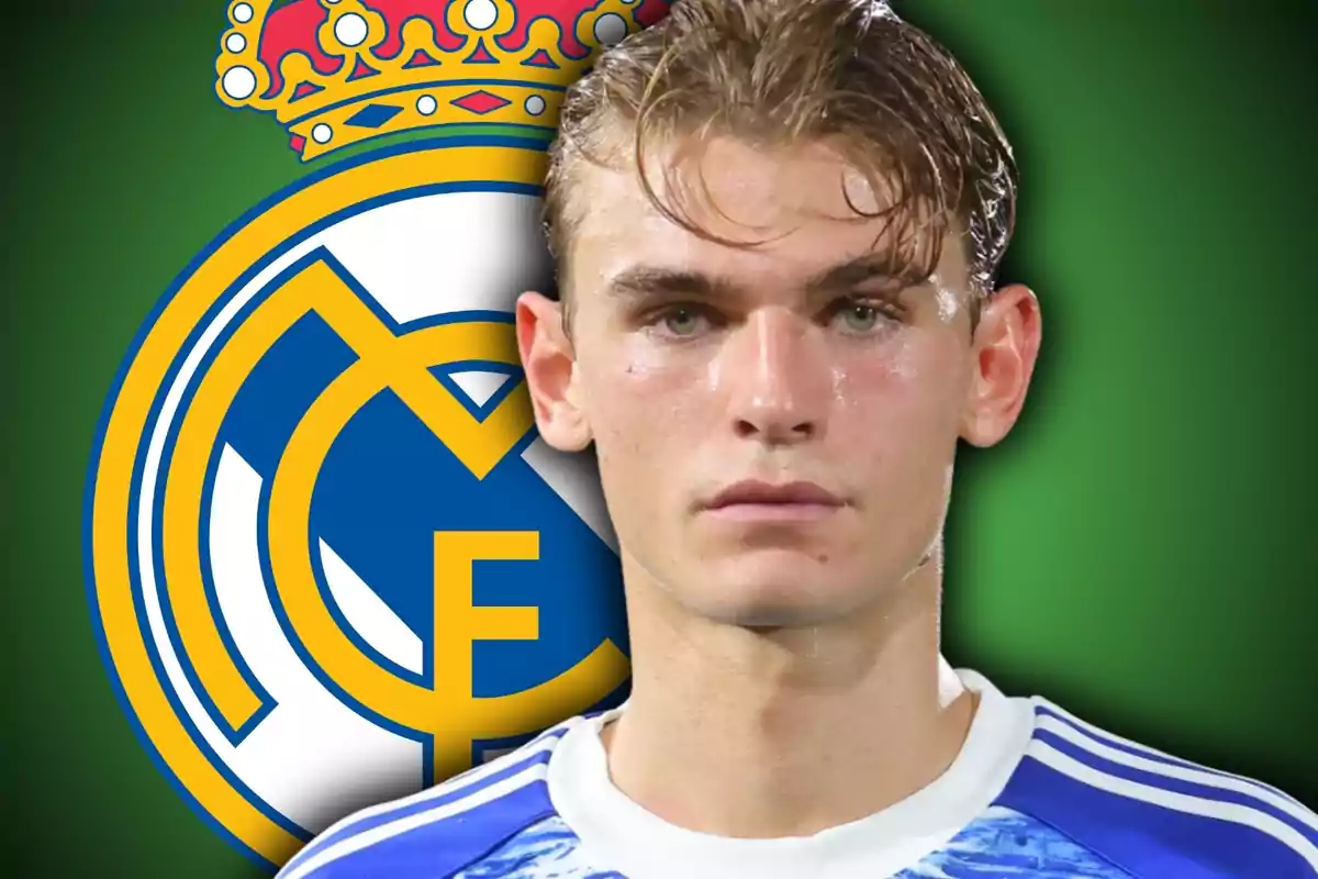 Jove futbolista amb samarreta blava davant de l’escut del Reial Madrid sobre fons verd