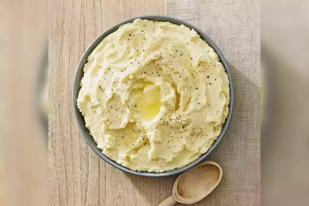 Sam's Club creamy mashed potatoes served in a gray bowl with melted butter in the center and sprinkled with black pepper, accompanied by a wooden spoon on a light wooden table. Sam's Club creamy mashed potatoes served in a gray bowl with melted butter in the center and sprinkled with black pepper, accompanied by a wooden spoon on a light wooden table.