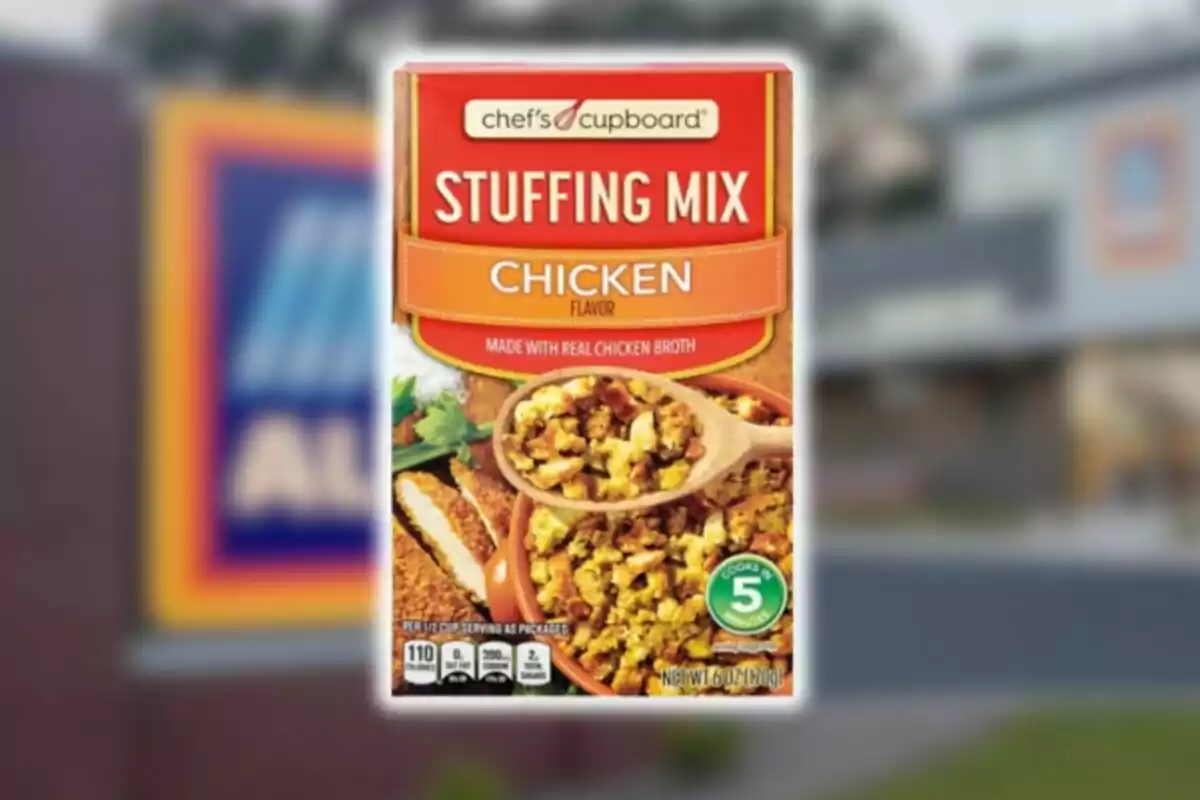 Caja de mezcla para relleno sabor pollo de la marca Chef’s Cupboard con una cuchara de madera y un plato con el producto preparado al frente de un fondo borroso de supermercado.