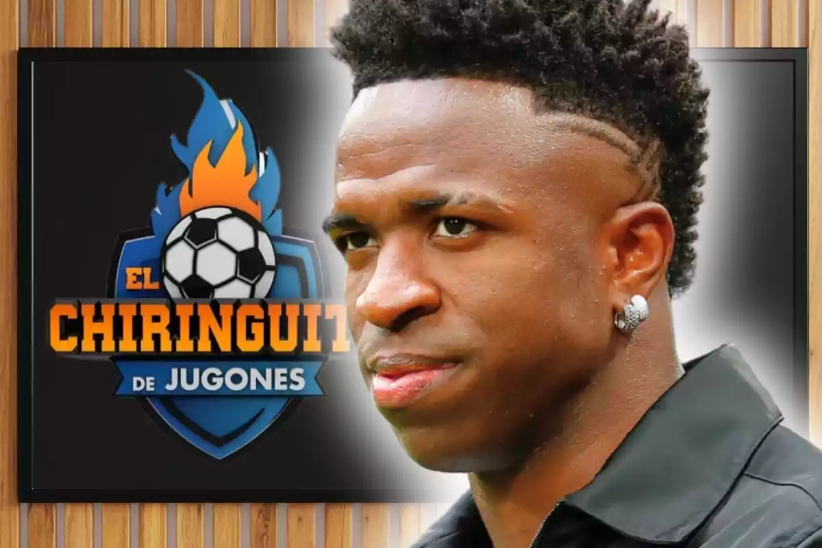 Un home de perfil amb arracada platejada i pentinat modern apareix davant d’una pantalla amb el logotip d’un programa esportiu anomenat El Chiringuito de Jugones sobre un fons de fusta.