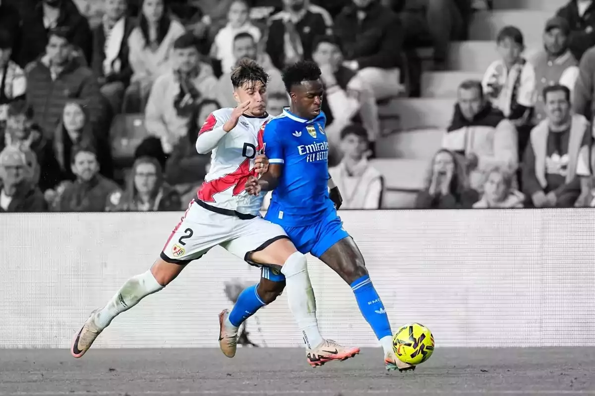 Dos futbolistes competeixen per la pilota en un partit mentre el fons és en blanc i negre i els jugadors i la pilota són en color. Dos futbolistes competeixen per la pilota en un partit mentre el fons és en blanc i negre i els jugadors i la pilota són en color.