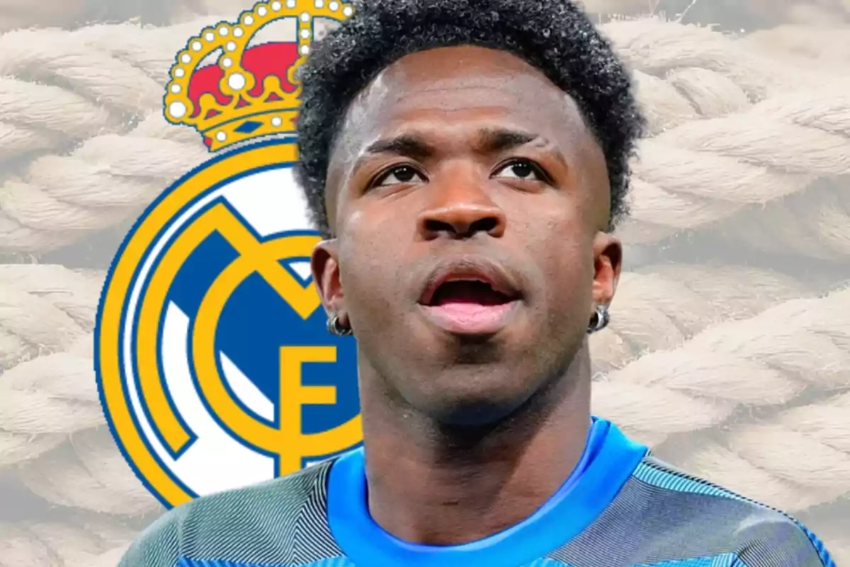 Jugador de fútbol con camiseta azul frente al escudo del Real Madrid y un fondo de cuerdas claras