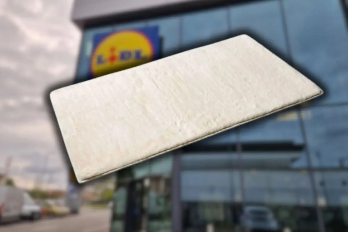 White rectangular mattress against a blurred background of the facade of a Lidl supermarket