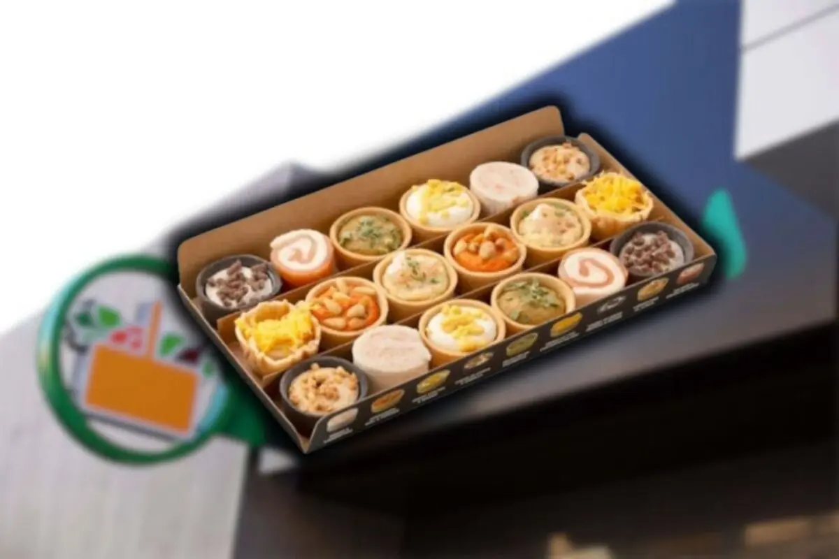 Caja de conos de pan rellenos con diferentes guisos y postres frente a un letrero de tienda. Caja de conos de pan rellenos con diferentes guisos y postres frente a un letrero de tienda.