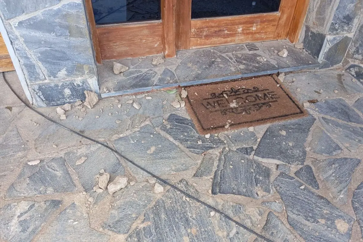 Puerta de madera con tapete de bienvenida sobre piso de piedra y escombros dispersos Puerta de madera con tapete de bienvenida sobre piso de piedra y escombros dispersos