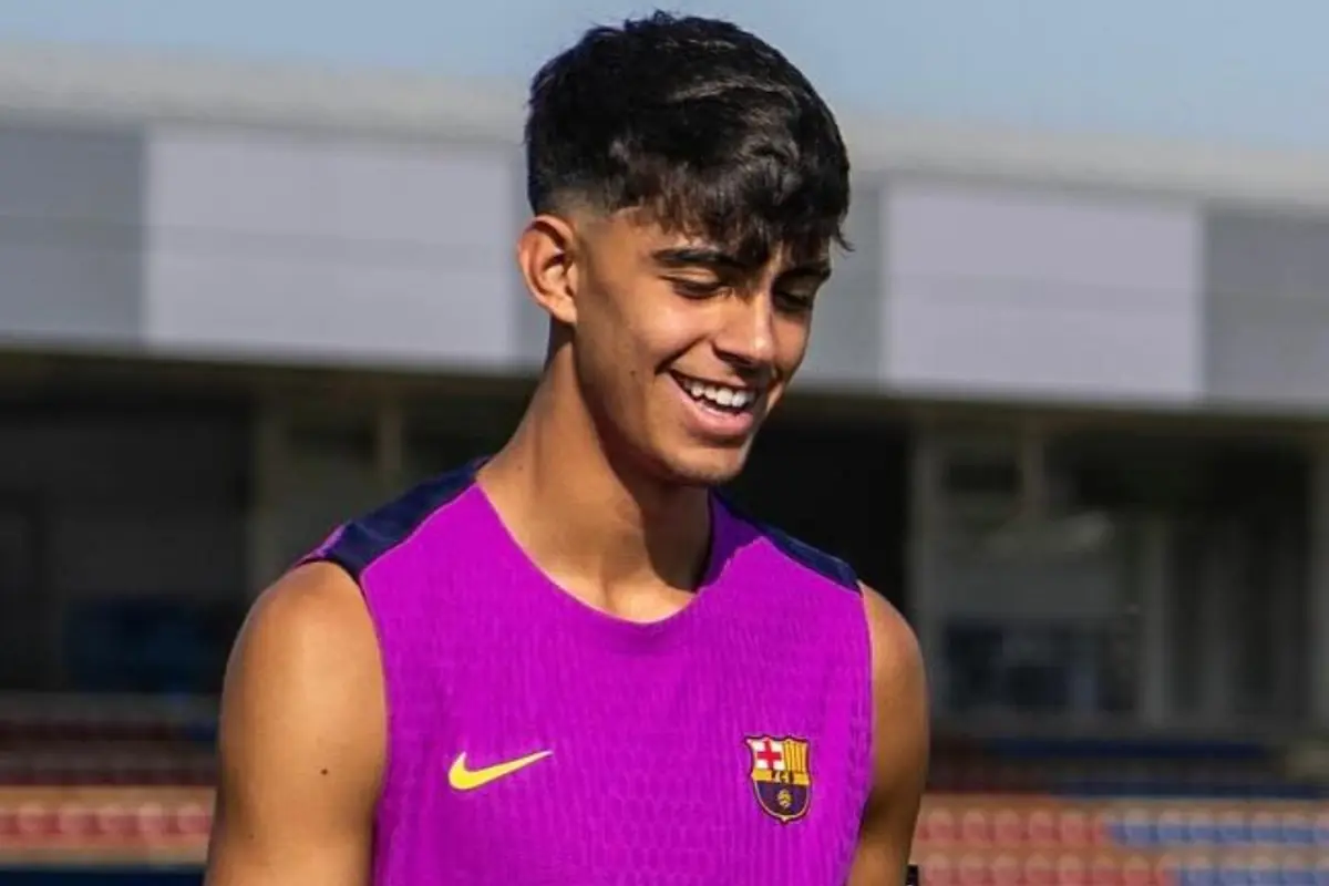 Jove amb samarreta d’entrenament del FC Barcelona somrient en un camp de futbol Jove amb samarreta d’entrenament del FC Barcelona somrient en un camp de futbol