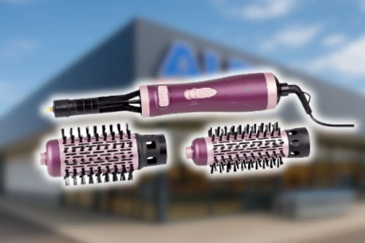 Cepillo de aire caliente eléctrico color rosa con dos cabezales intercambiables de cerdas negras sobre fondo desenfocado de tienda Aldi.