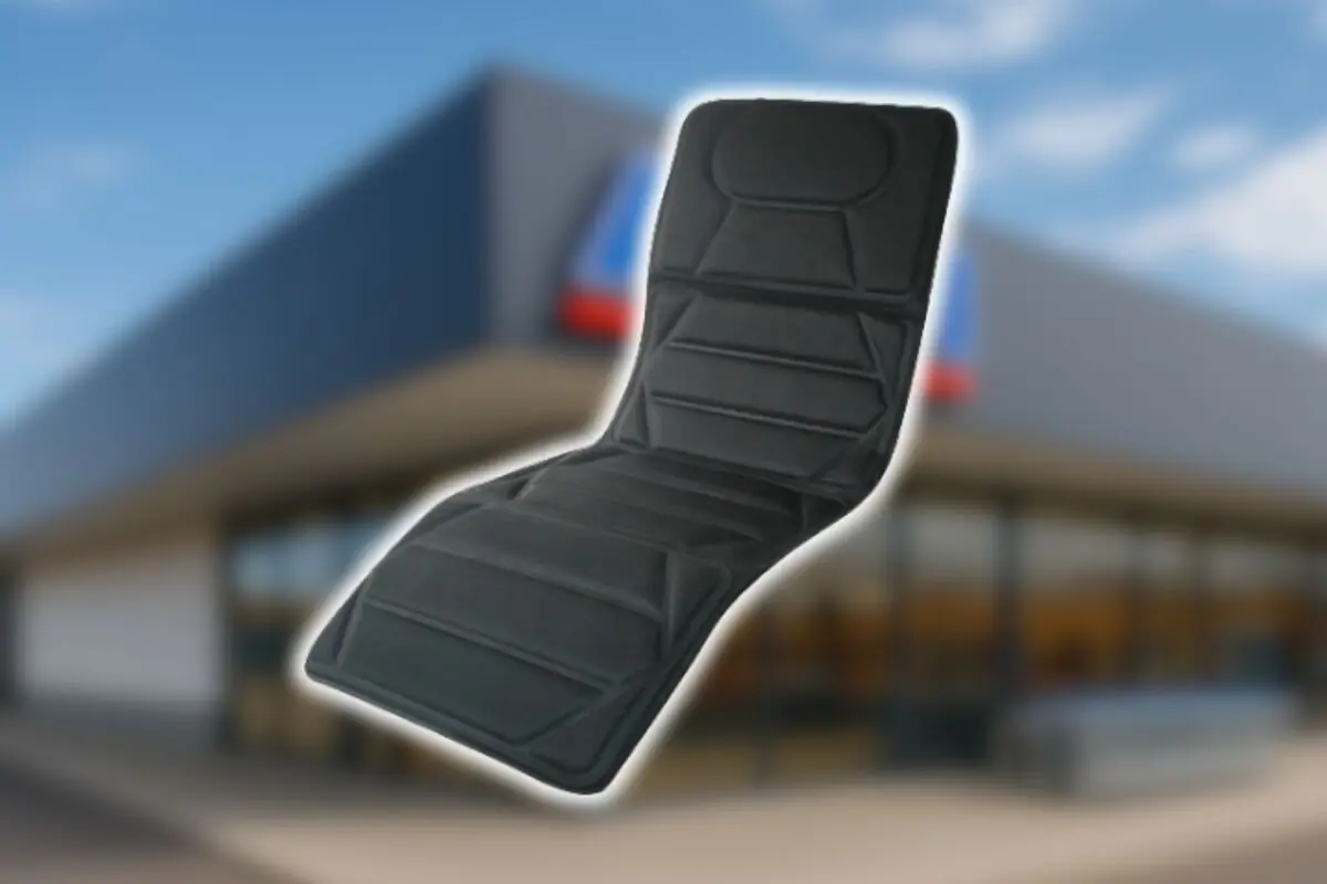 Cojín acolchado negro para asiento de coche sobre fondo de tienda desenfocado de Aldi.