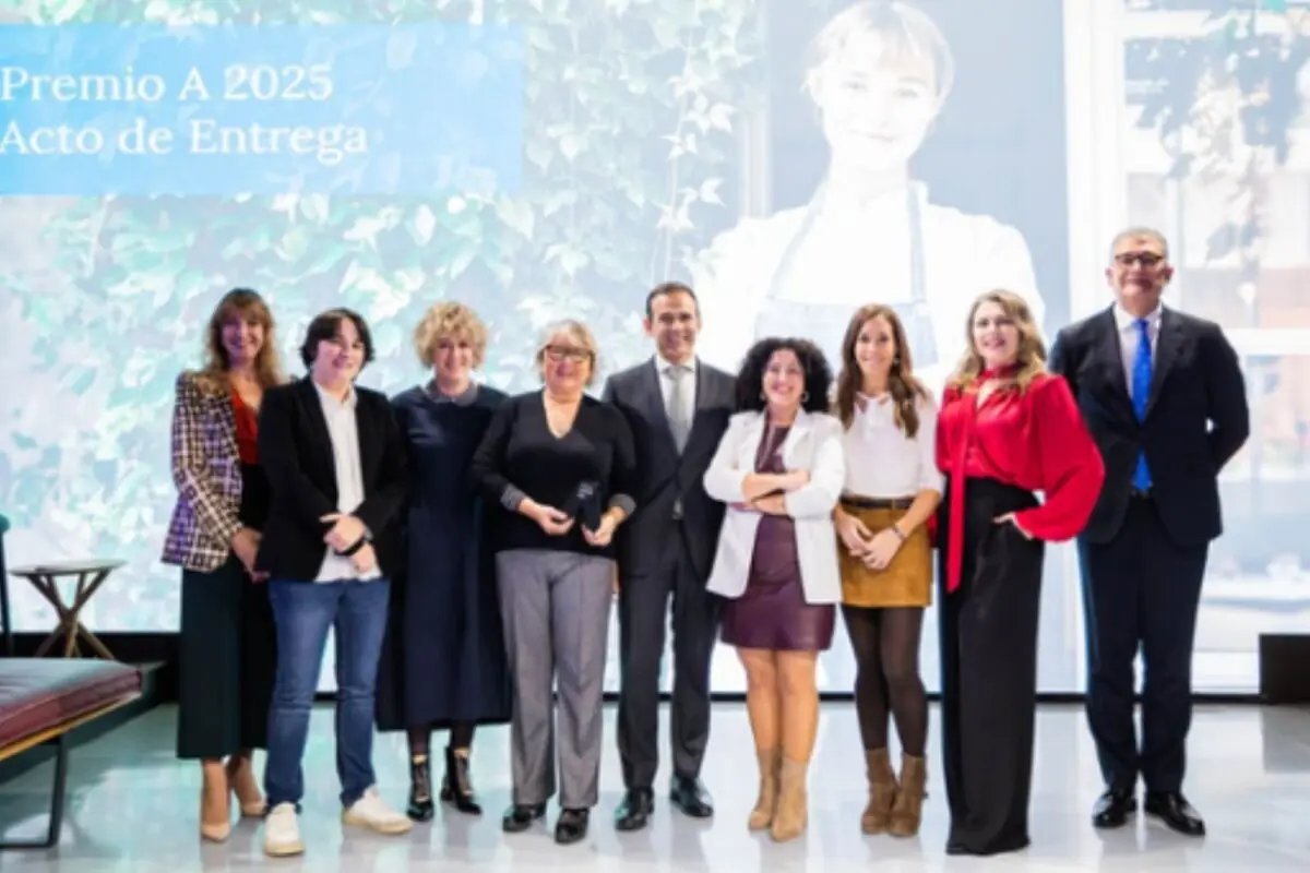 Grupo de personas posando juntas en un evento formal con un fondo que muestra texto y la imagen de una mujer sonriente; entre ellos: el director de Negocio de CaixaBank, Jaume Masana; la ganadora del ‘Premio A Profesional Autónoma’ de 2025, Ángela Jordana, y el director comercial segmento Negocios de CaixaBank, Toni Rodríguez.