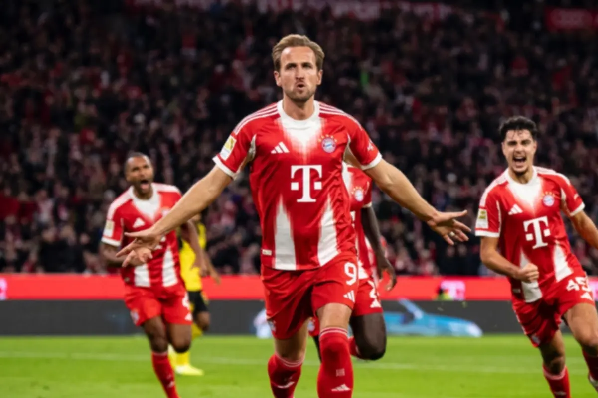 Bayern Munich player celebrating a goal with arms outstretched while his teammates run behind him in the stadium.