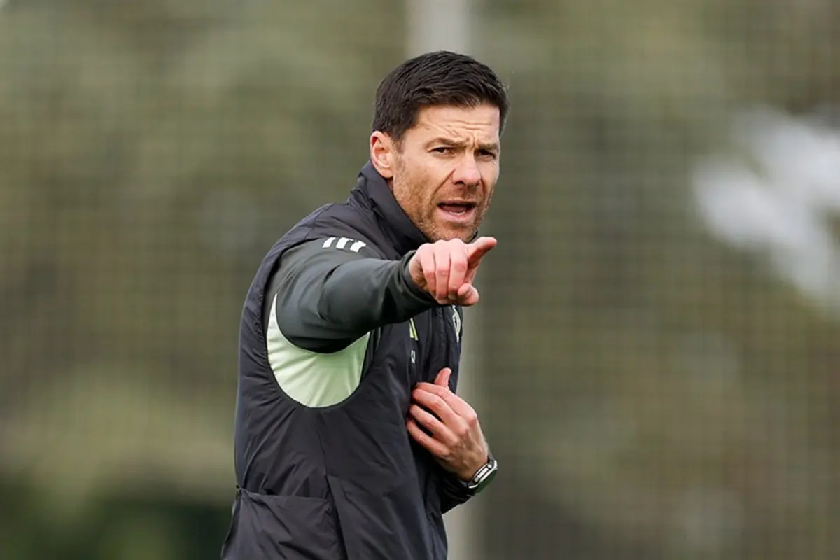 Entrenador de fútbol en el campo señalando con el dedo hacia adelante durante una indicación táctica