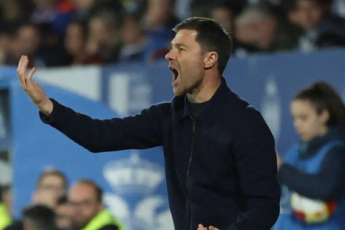 Entrenador de fútbol en la banda gesticulando con la mano y gritando durante un partido