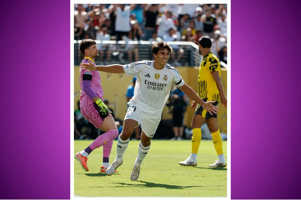 Futbolista del Reial Madrid celebra un gol amb els braços oberts davant del porter rival i un defensor amb uniforme groc sobre un camp de joc ple de públic