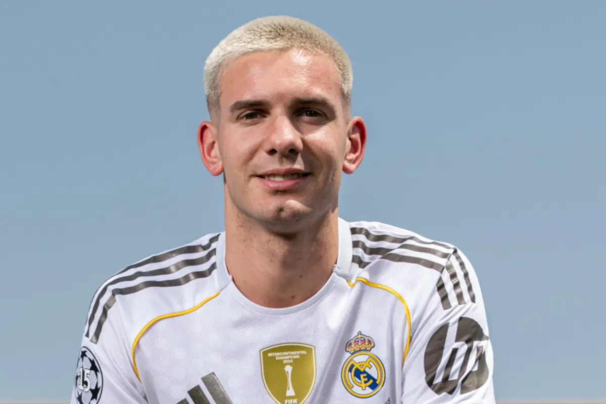 Young man with short blond hair wearing Real Madrid’s white uniform smiles in front of a clear sky Young man with short blond hair wearing Real Madrid’s white uniform smiles in front of a clear sky