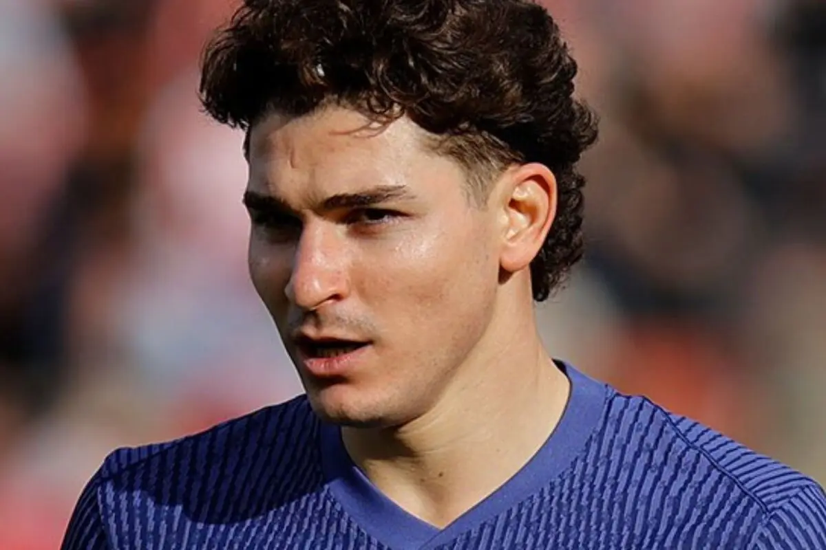 Jugador de futbol de cabell arrissat amb samarreta blava en primer pla durant un partit