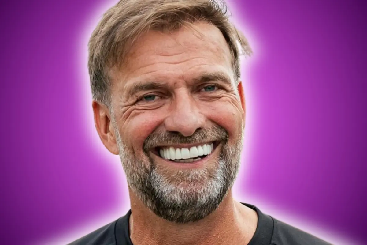 Hombre de cabello castaño y barba sonriente con fondo morado difuminado