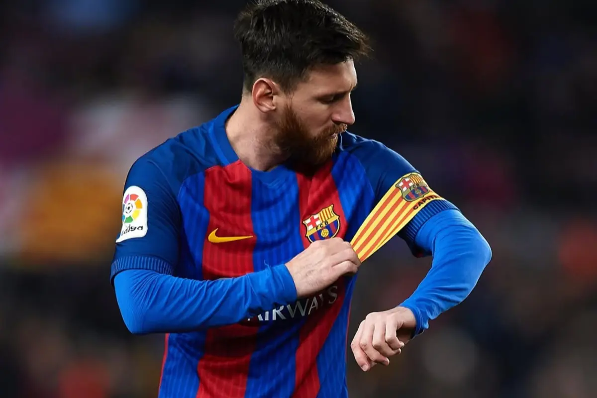 Futbolista del FC Barcelona ajustando el brazalete de capitán durante un partido
