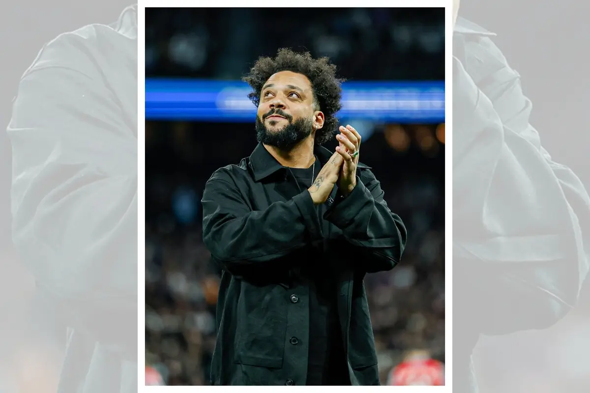 Home amb barba i cabells arrissats aplaudint i mirant cap amunt en un estadi