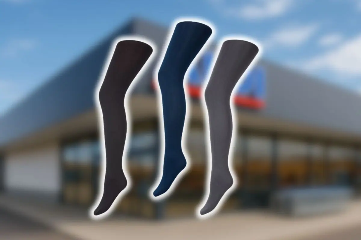 Tres medias opacas en tonos oscuros sobre un fondo desenfocado de fachada de una tienda Aldi.