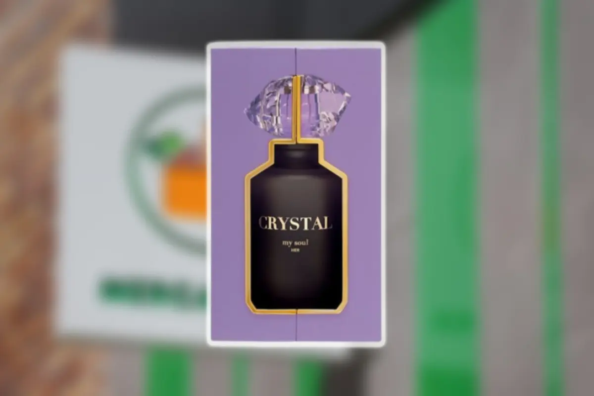 Caja morada de perfume Crystal my soul con frasco negro y tapa en forma de diamante sobre fondo desenfocado