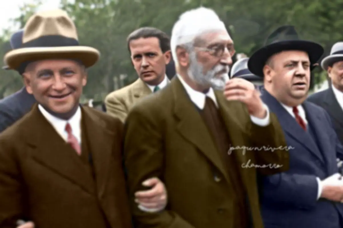 Grup d’homes amb vestits i barrets, entre ells Miguel de Unamuno, caminant junts en una escena històrica a l’aire lliure.