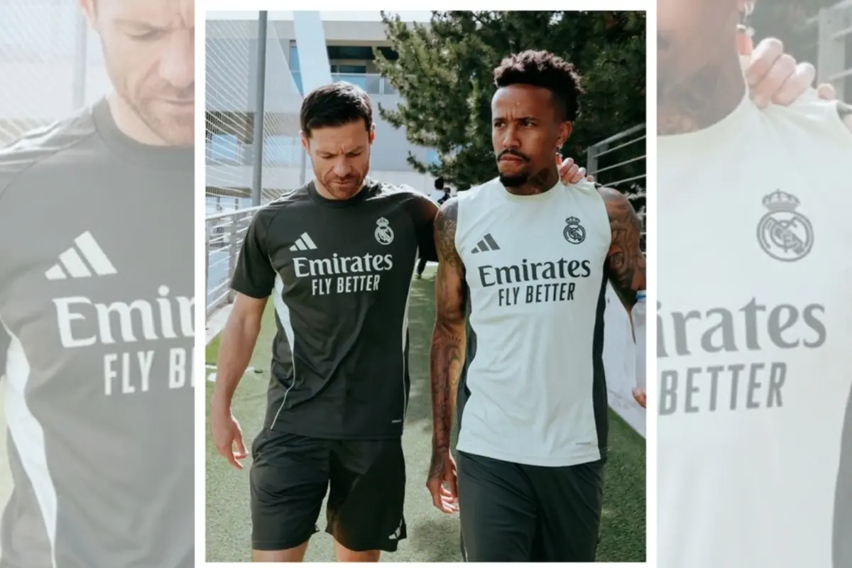 Dos futbolistes del Reial Madrid caminant junts en un camp d’entrenament, tots dos amb roba esportiva de l’equip