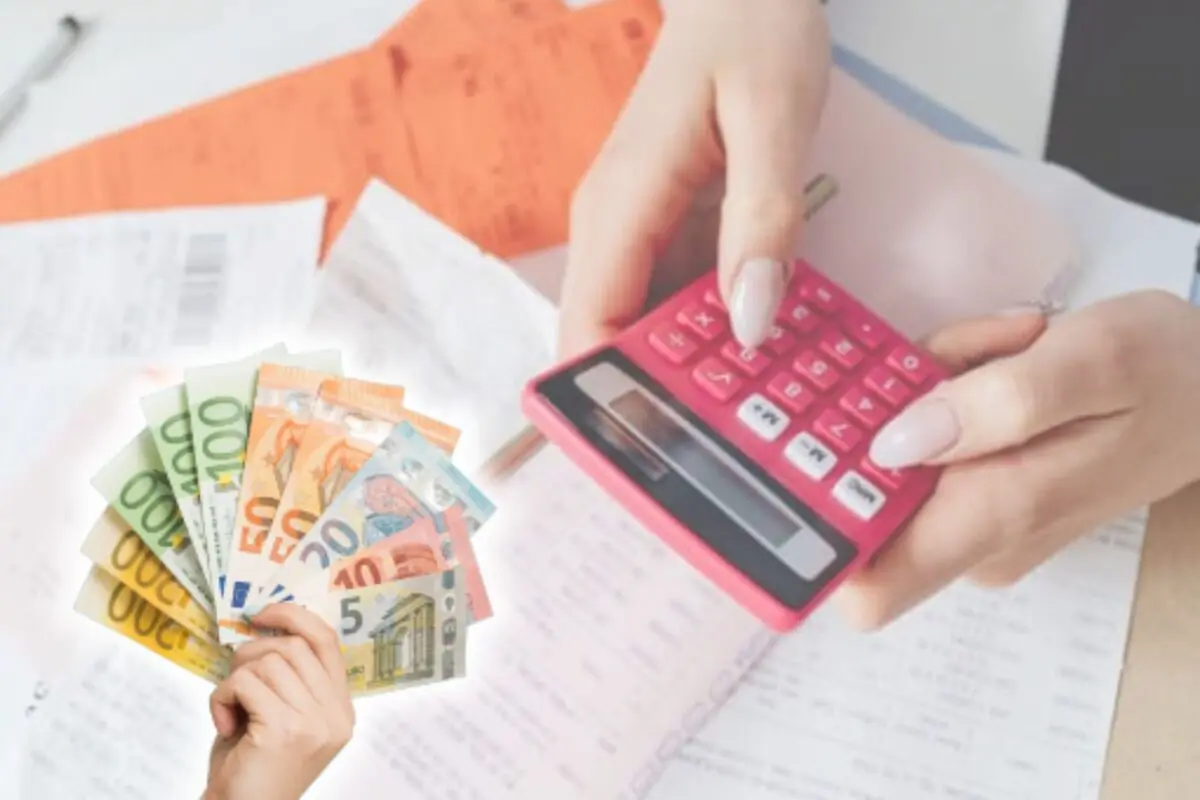 Mà utilitzant una calculadora rosa sobre factures mentre una altra mà sosté bitllets d’euro de diferents denominacions.
