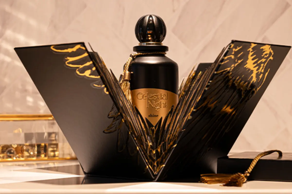 Perfume elegante en envase negro y dorado con caja decorativa abierta y detalles dorados