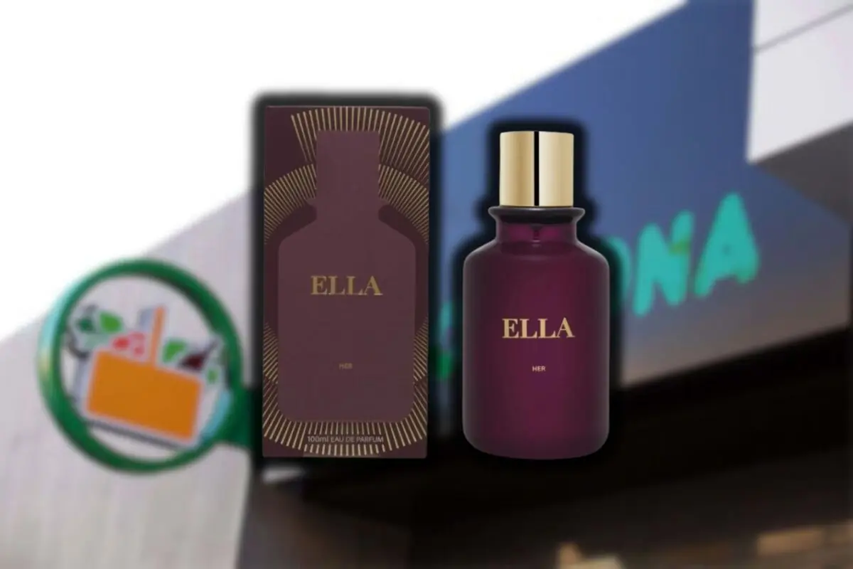 Perfume ELLA con caja y frasco color vino con tapa dorada frente a una tienda con letrero borroso Perfume ELLA con caja y frasco color vino con tapa dorada frente a una tienda con letrero borroso